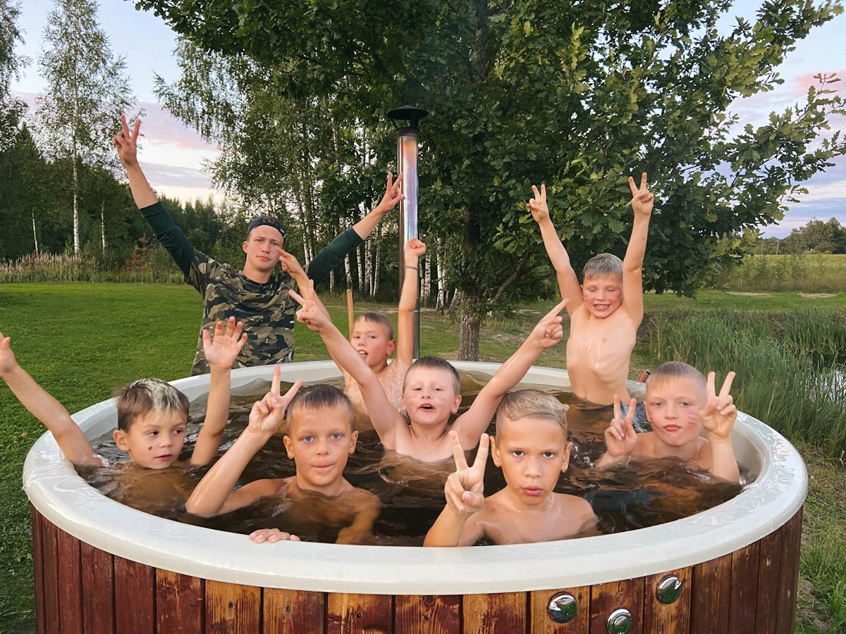 Bērns smaida draugu lokā vasaras nometnē Latvijā